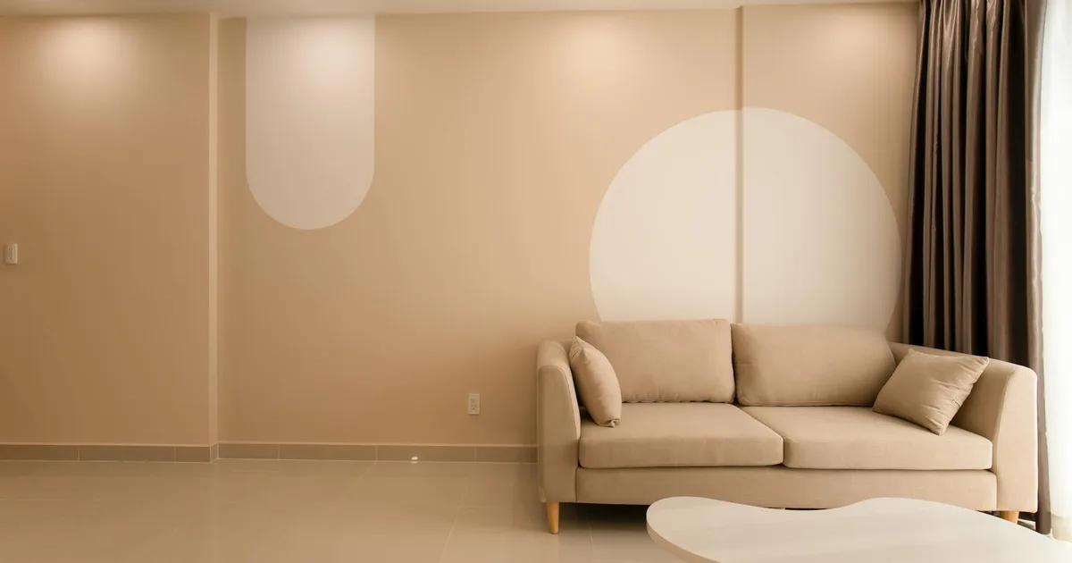 A cozy minimalist living room featuring a beige sofa, modern decor, and neutral tones for an inviting atmosphere.