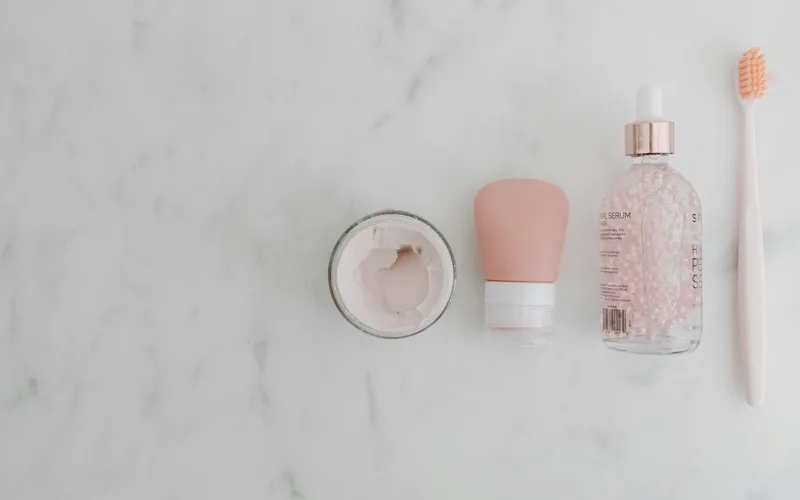 Top view of assorted beauty products on a marble surface with copy space.