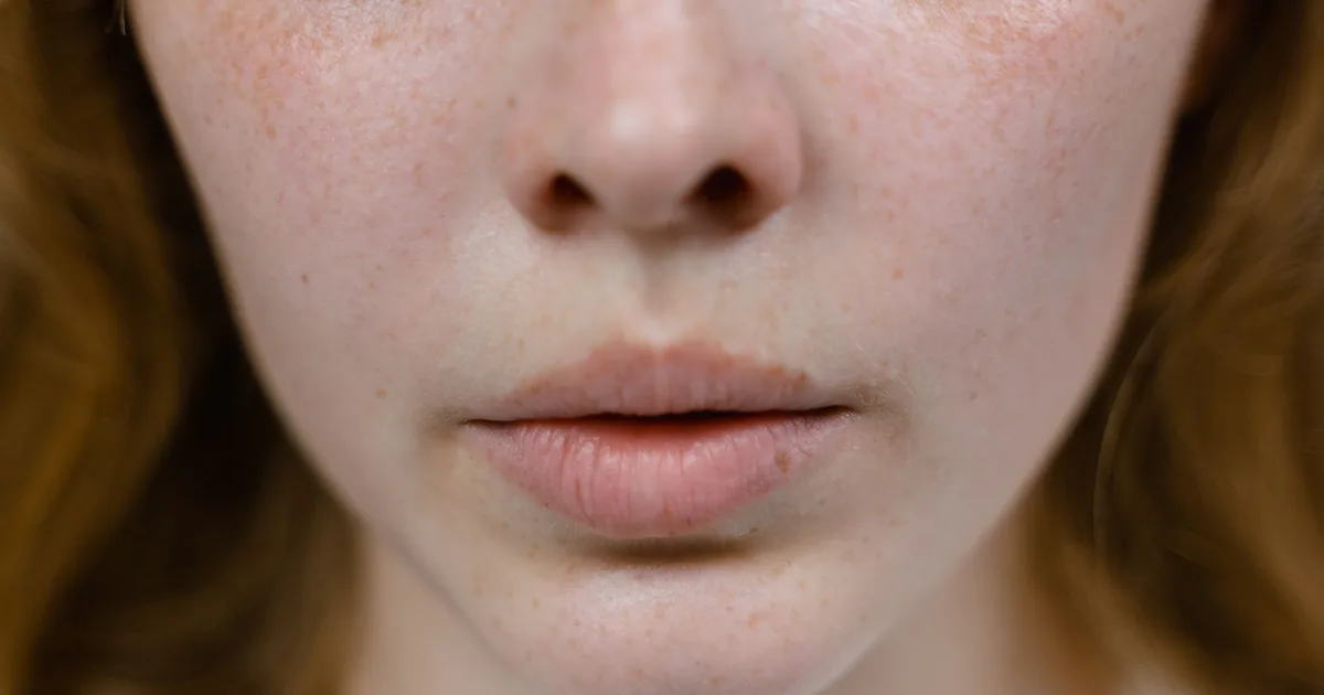 Detailed close-up of a freckled female face focusing on natural features and textures.
