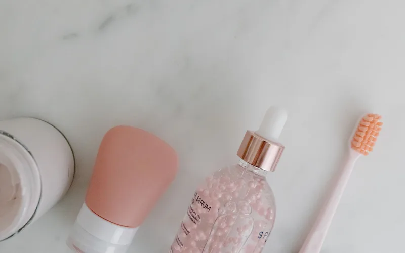Top view of skincare products with toothbrush on marble background. Perfect for beauty and wellness themes.