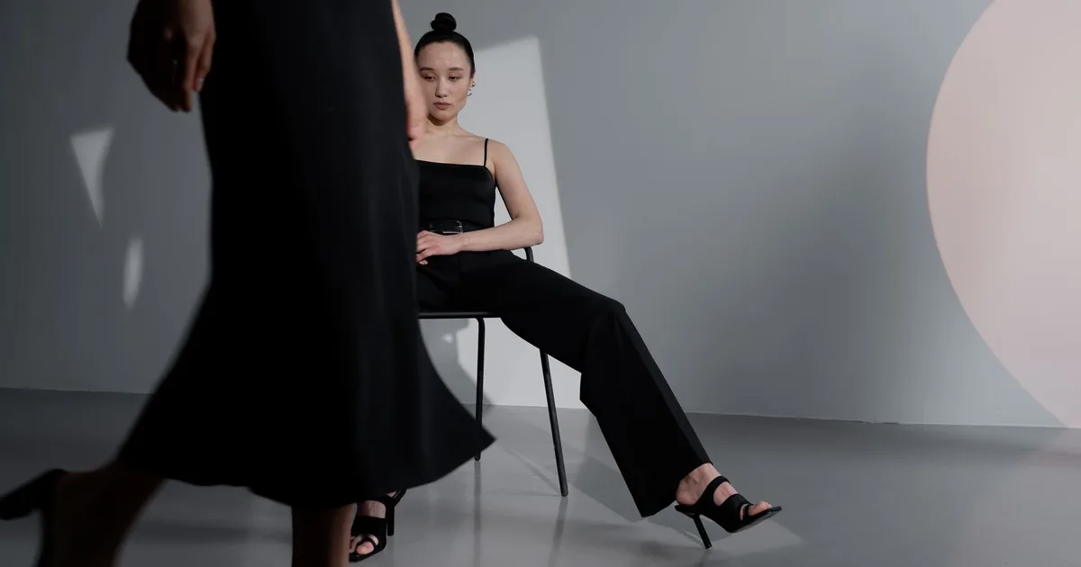 Chic and modern fashion photoshoot featuring a woman in black in a stylish studio setup.