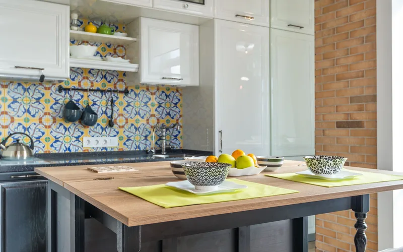 Stylish contemporary kitchen with vibrant printed tiles, wooden tabletop, and elegant interior.