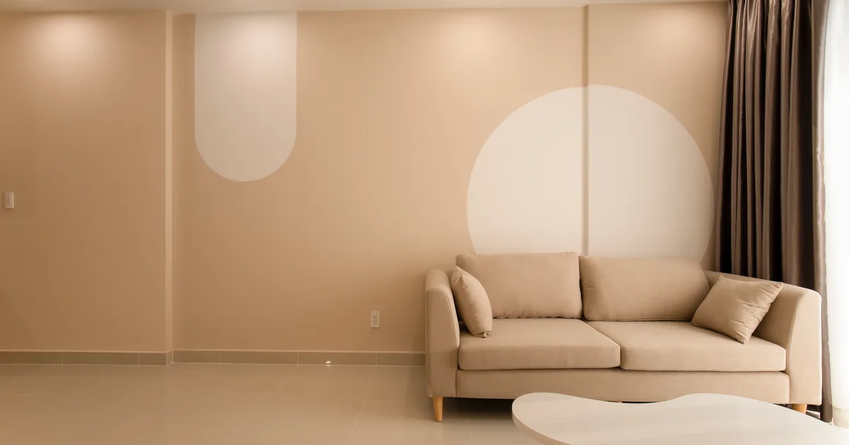 A cozy minimalist living room featuring a beige sofa, modern decor, and neutral tones for an inviting atmosphere.