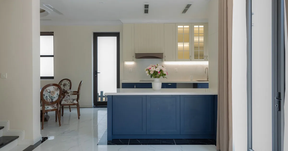 Bright and elegant modern kitchen featuring blue cabinetry and marble flooring.