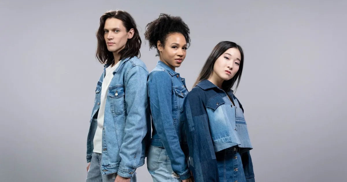 Three diverse models posing in stylish denim outfits in a studio setting.