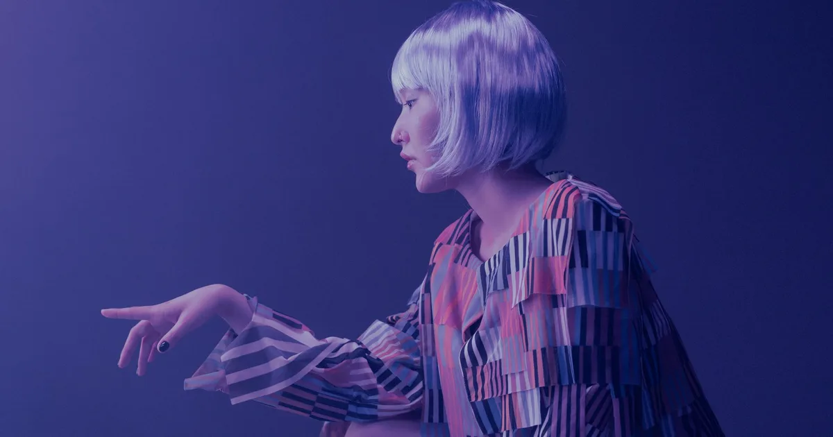 Artistic portrait of a woman in vibrant striped outfit and silver bob wig, conceptual style.