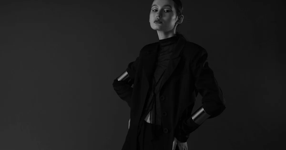 Sophisticated portrait of a woman with short hair posing elegantly in a monochrome studio setting.