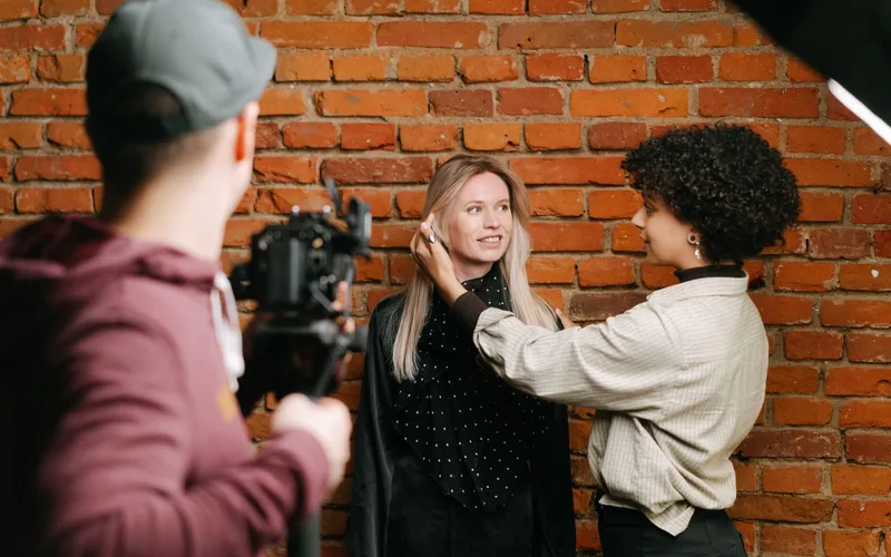 Diverse team at photoshoot setting up against a brick wall. Capturing fashion and style behind the scenes.