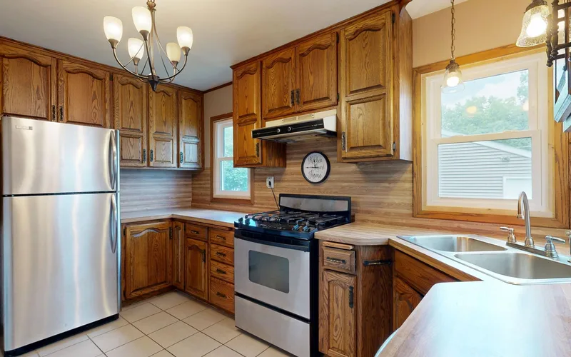 Cozy kitchen interior featuring wooden cabinets and stainless steel appliances for a homely atmosphere.