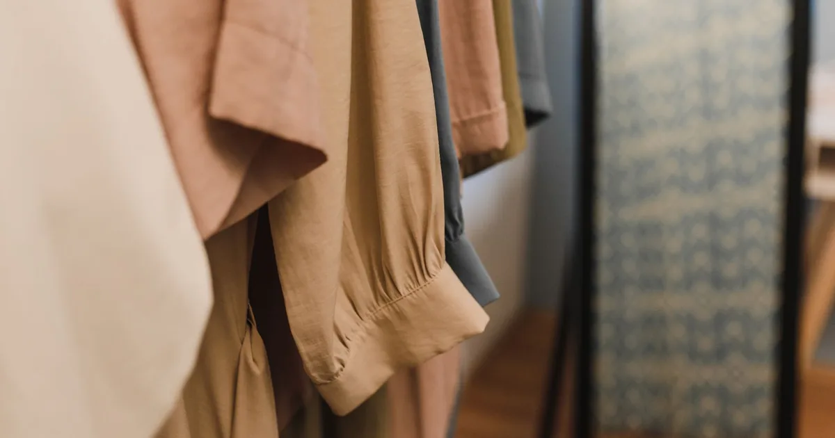 A detailed view of various garments hanging neatly in a clothing wardrobe.
